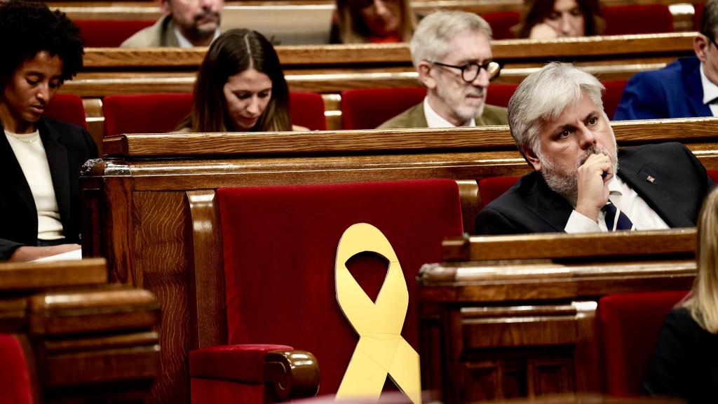 Albert Batet, presidente del grupo parlamentario de Junts, escucha la intervención de Salvador Illa en el Parlament con el escaño de Carles Puigdemont vacío