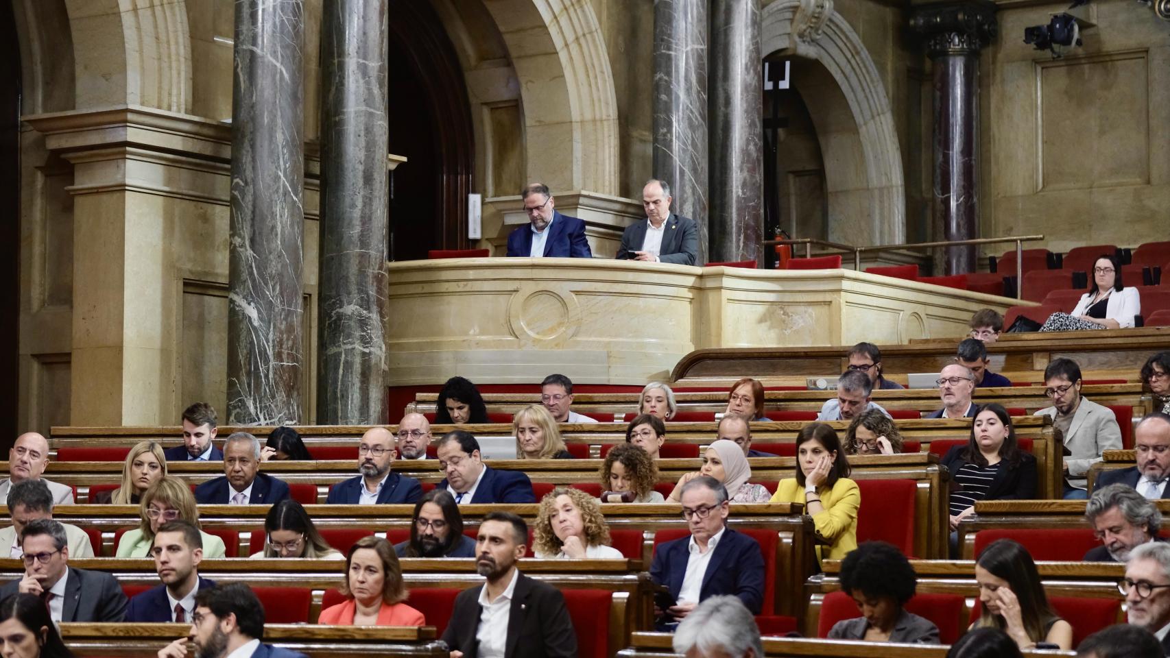 Oriol Junqueras, presidente de ERC, y Jordi Turull, secretario general de Junts, supervisan la estrategia de sus partidos como invitados al Parlament durante el Debate de Política General