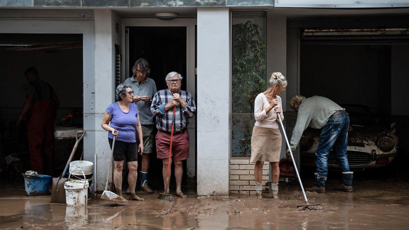 Varios vecinos limpian el barro de las calles de Sant Carles de la Ràpita