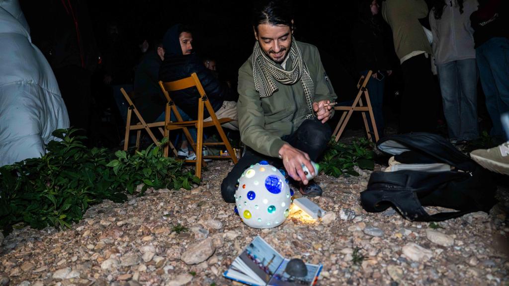 Un hombre muestra las lámparas con las que se propone evitar la extinción de la humanidad