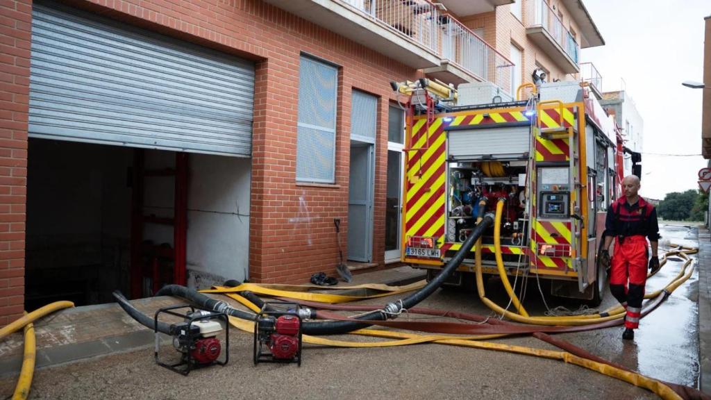 Un camión de Bombers saca el agua de un local inundado por la DANA 'Alice' en Santa Bàrbara
