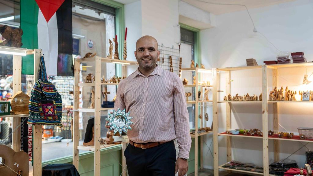 Anton Mickel, propietario de la tienda Bethlehem Treasures, sujetando una figura de nácar