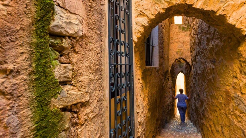 Una mujer pasea por la calle más estrecha de Cataluña, que está en Tarragona