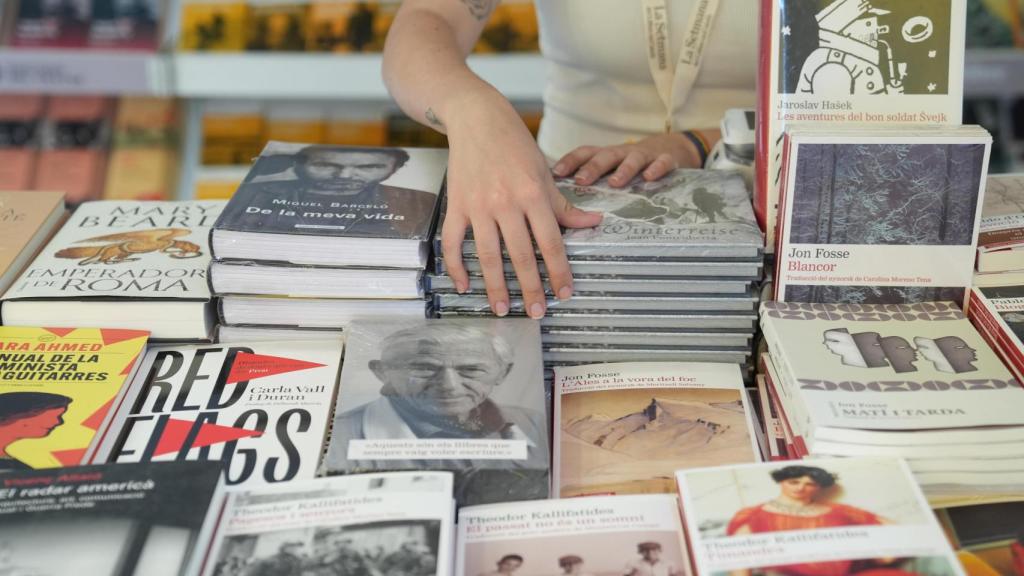 Una persona coloca los libros durante la 43 Setmana del Llibre en Català, a 19 de septiembre de 2025, en Barcelona