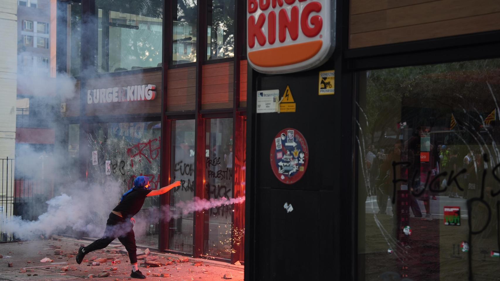 Un manifestante lanza una bengala contra un Burger King durante la manifestación propalestina de este miércoles 15 de octubre en Barcelona