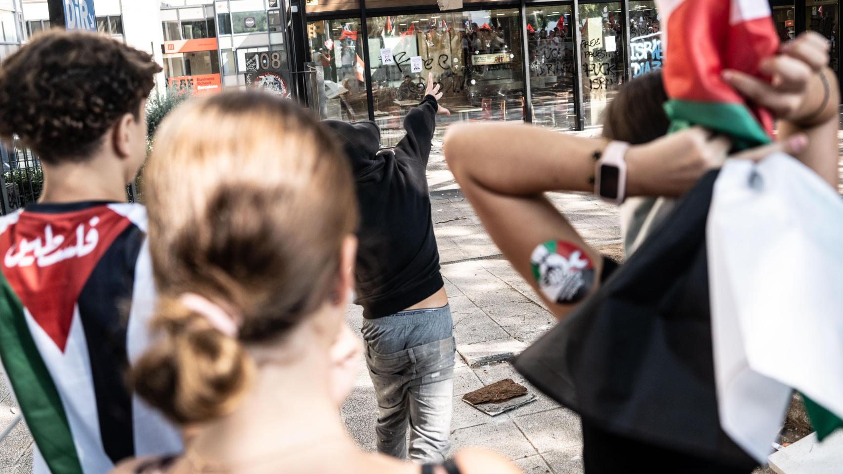Un joven lanza una piedra al local del Burger King de Barcelona ubicado en la calle Tarragona durante la manifestación en apoyo a Palestina