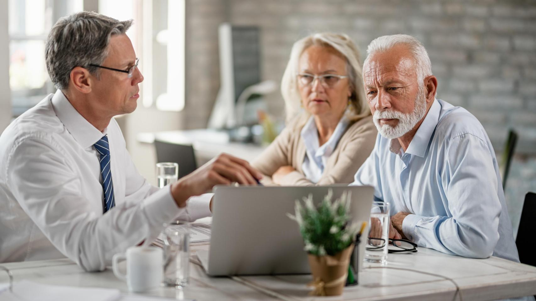 Una pareja mayor solicita información en una oficina bancaria