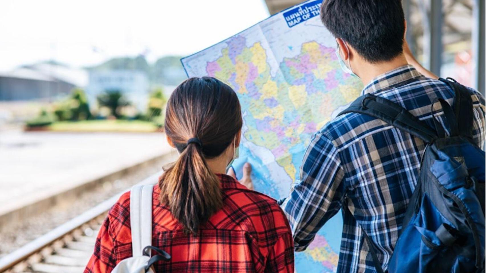 Una pareja prepara su ruta mirando un mapa