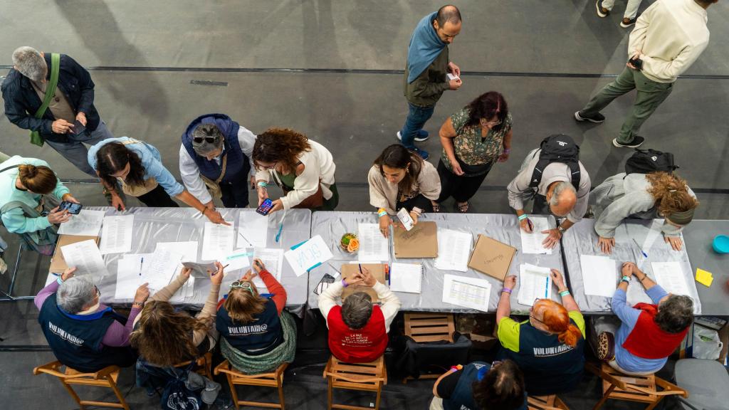 Varias personas rellenan formularios para apuntarse como voluntarios de la comunidad de Amma en Granollers