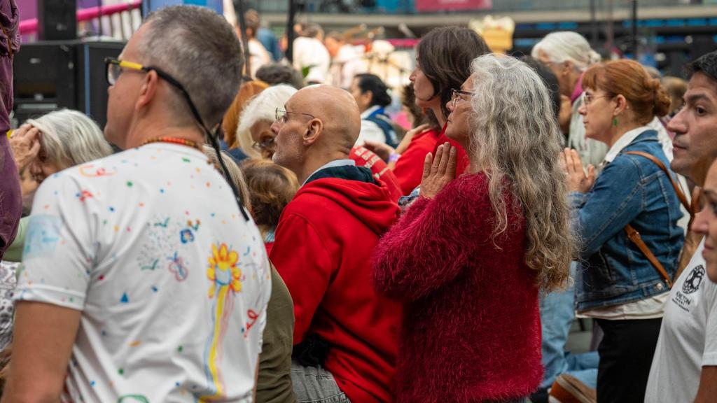 Decenas de personas esperan, arrodilladas, la llegada de Amma a Granollers