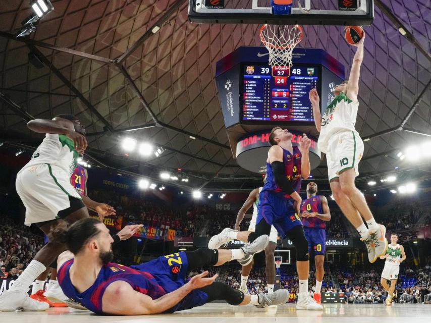 Un jugador del Zalgiris supera a Jan Vesely i Toko Shengelia sota l'anella