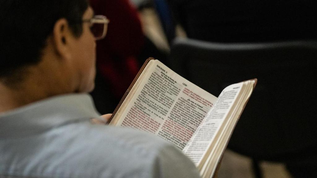 Un hombre consulta la 'Biblia' durante un servicio de la iglesia Elim en Girona