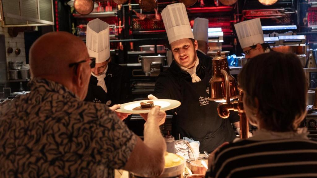 Los clientes son atendidos en la sección de La Rôtisserie, donde se preparan los platos calientes, en el restaurante francés Les Grands Buffets