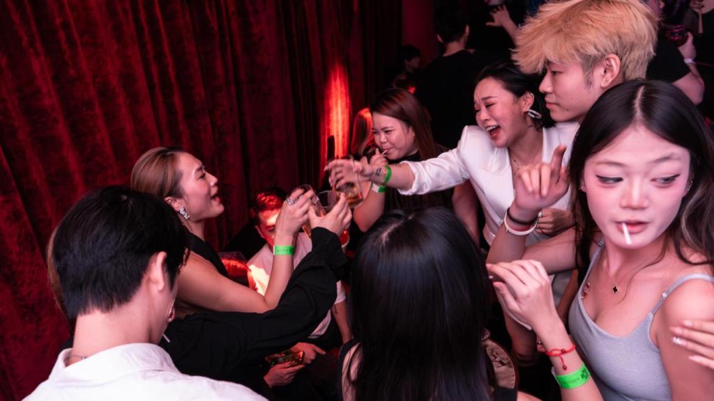 Varios asistentes a la Eco Party de Halloween brindan sus copas en el reservado de Ku