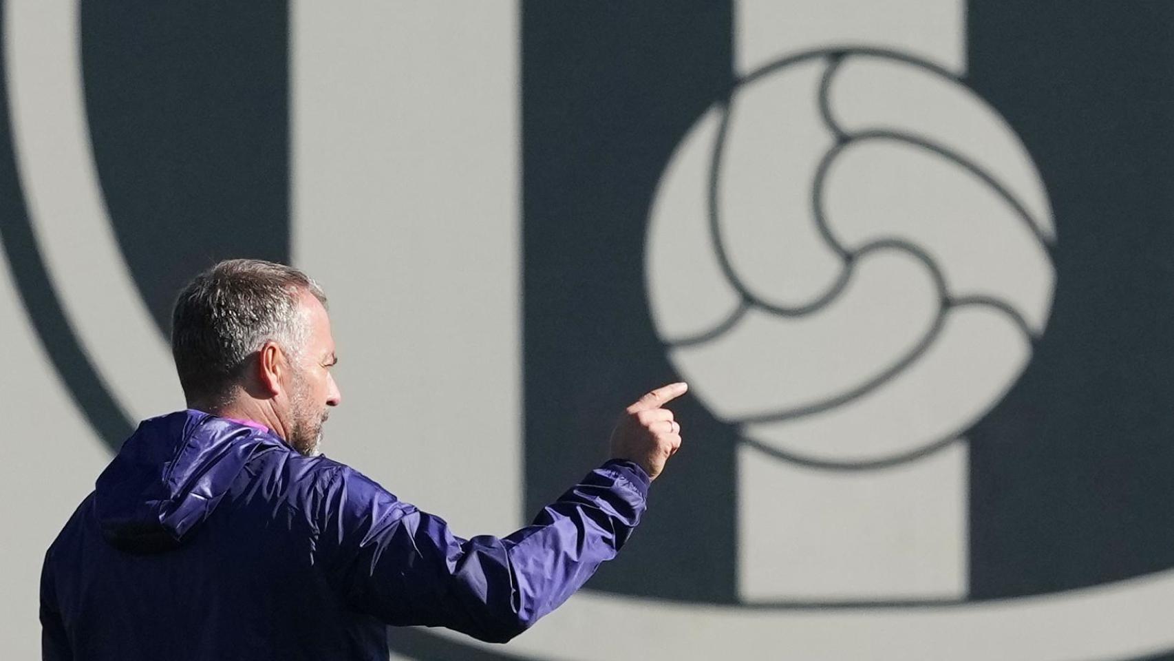 Hansi Flick, en el entrenamiento previo al Brujas-Barça, con el escudo del club azulgrana de fondo