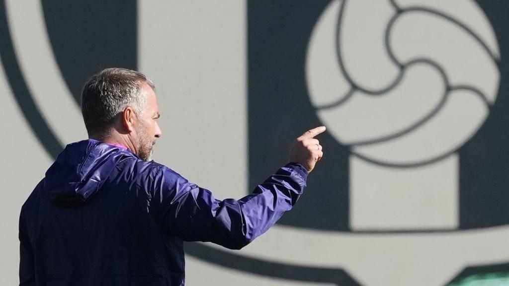 Hansi Flick, en el entrenamiento previo al Brujas-Barça, con el escudo del club azulgrana de fondo