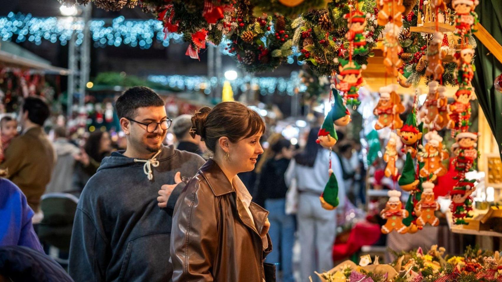 Dos jóvenes miran un puesto con artículos de Navidad