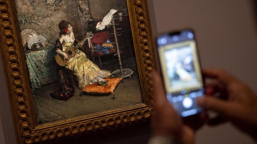 Un visitant fa fotografies amb el mòbil del llenç de Raimundo de Madrazo ‘Dama amb lloro’ (1872).