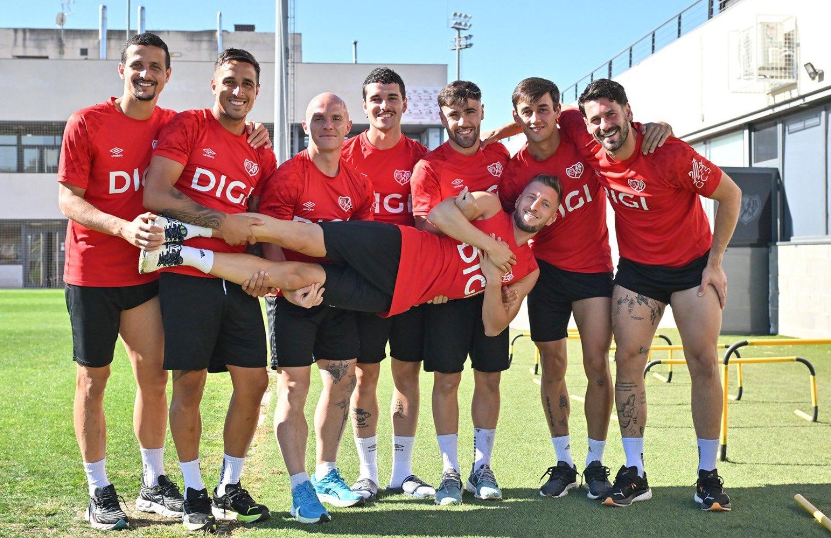 Iván Balliu, un dels capitans del Rayo Vallecano, subjectat per diversos companys