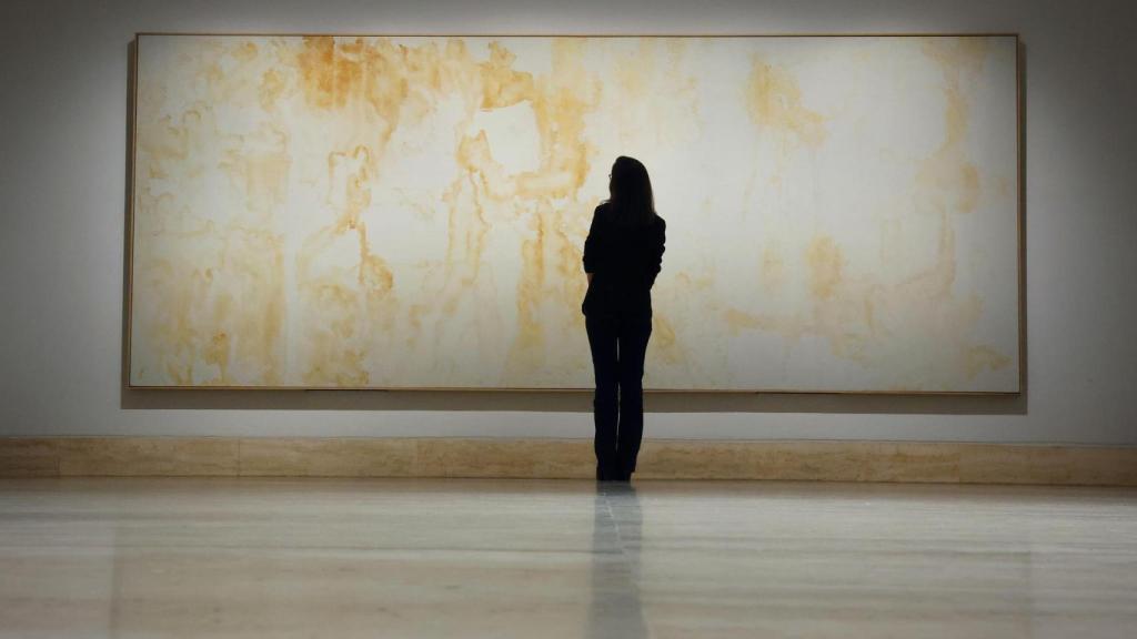 Una dona observa una de les pintures d'orina d'Andy Warhol.