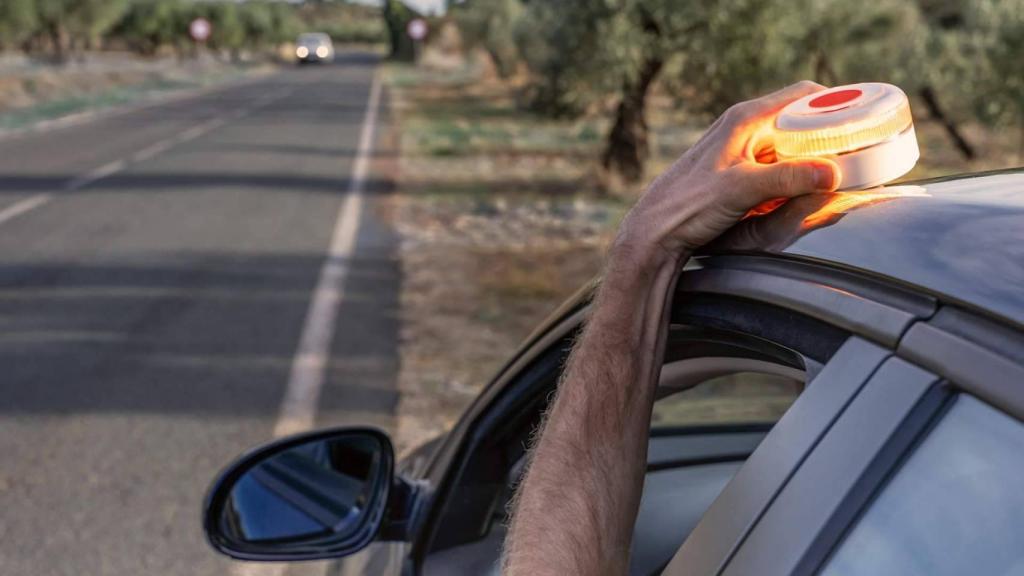 Conductor coloca la baliza V16 en el techo de su coche