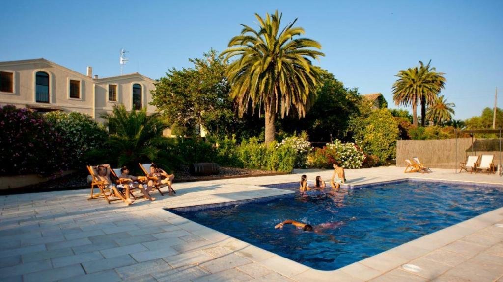 Varios huéspedes en la piscina de Mas Palou