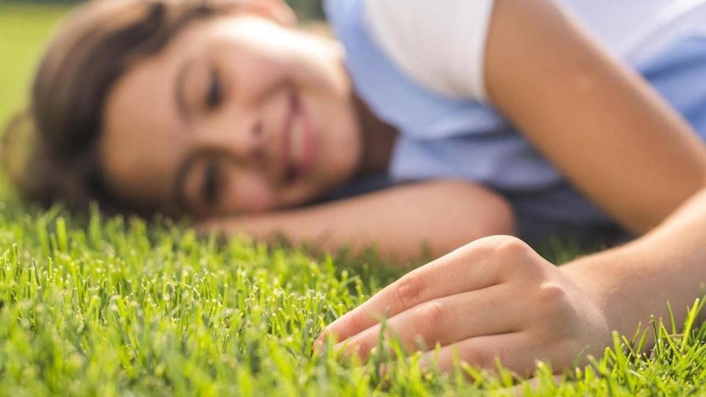 Mujer acaricia un césped artificial
