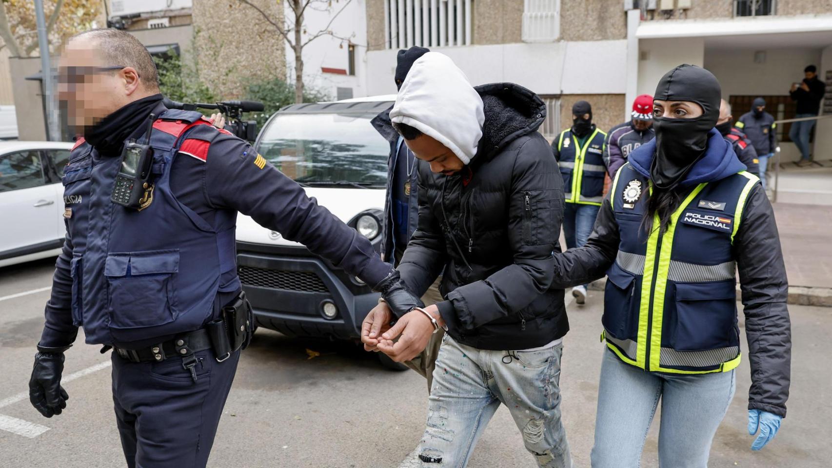 Agentes de los Mossos d'Esquadra y de la Policía Nacional custodian a varios de los Trinitarios detenidos en L'Hospitalet de Llobregat