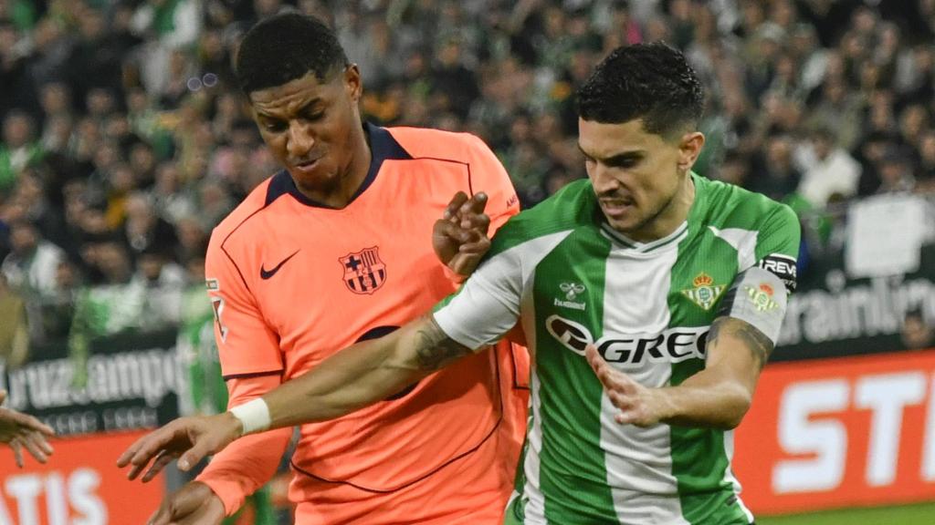 Marcus Rashford lluita per la pilota amb Marc Bartra al Betis-Barça de la Lliga