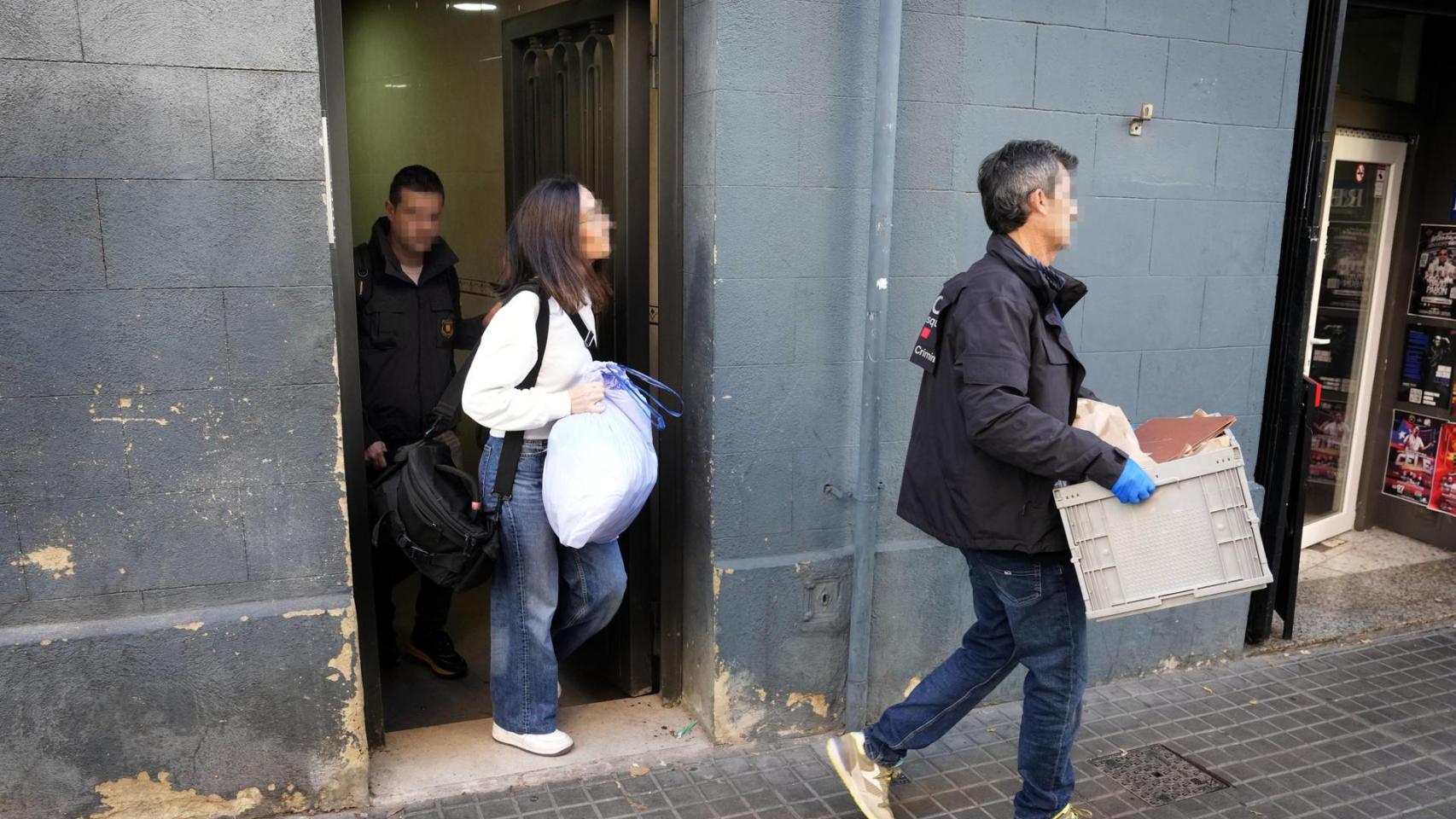 Varios agentes de los Mossos d'Esquadra salen del número 45 de la calle Santa Eulàlia de L'Hospitalet de Llobregat