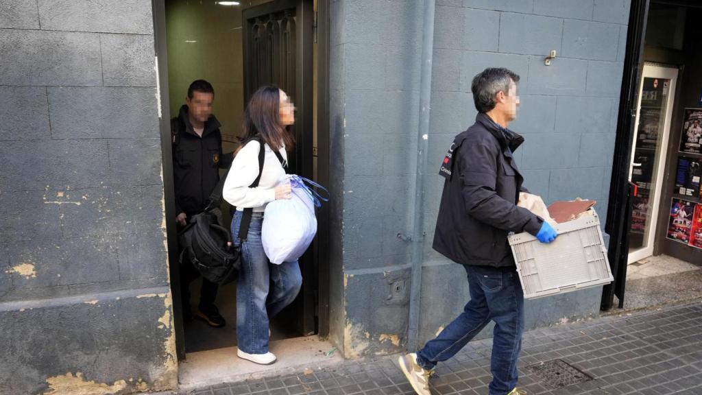 Varios agentes de los Mossos d'Esquadra salen del número 45 de la calle Santa Eulàlia de L'Hospitalet de Llobregat