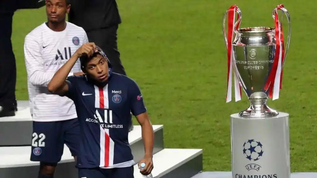 Kylian Mbappé pasa al lado del trofeo de la Champions en 2020