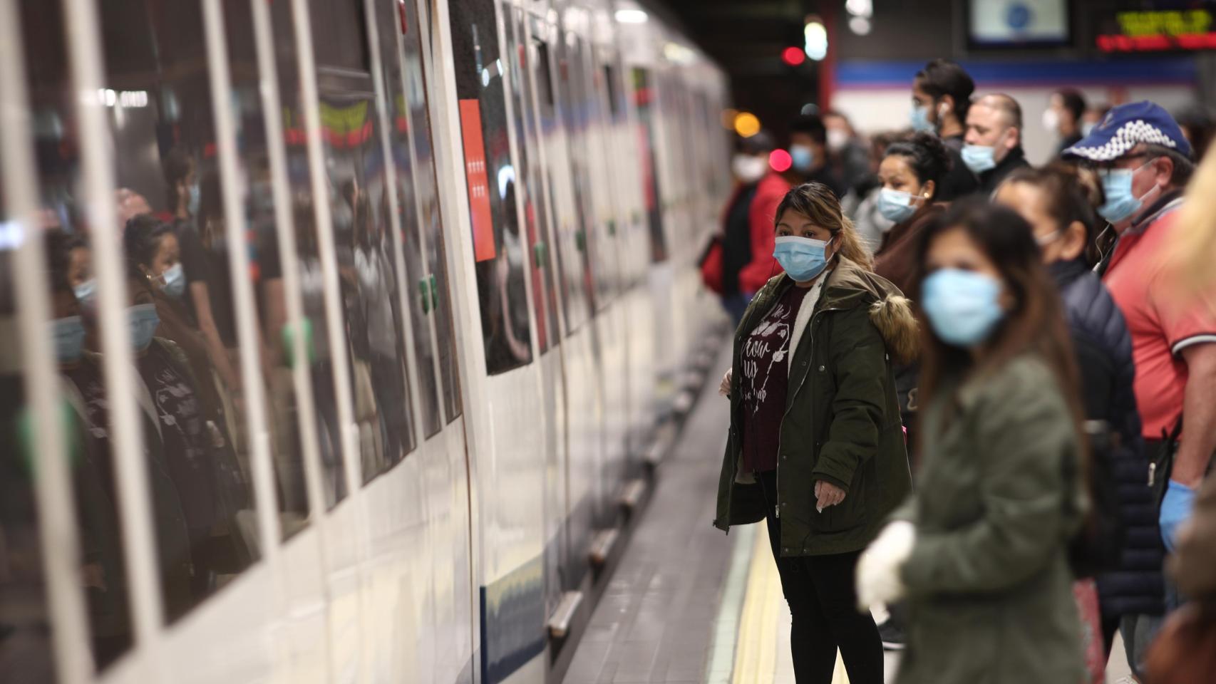 Varias personas, con mascarilla, en una parada de metro