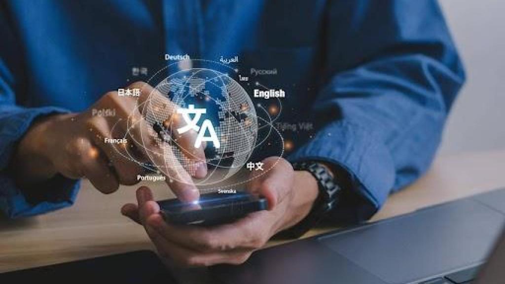 Persona con móvil en las manos y globo terraqueo superpuesto indicando diferentes idiomas