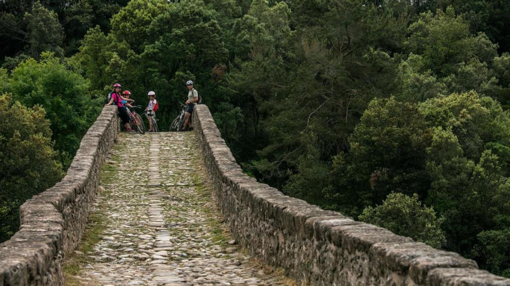 Ciclistas en un puente de piedra