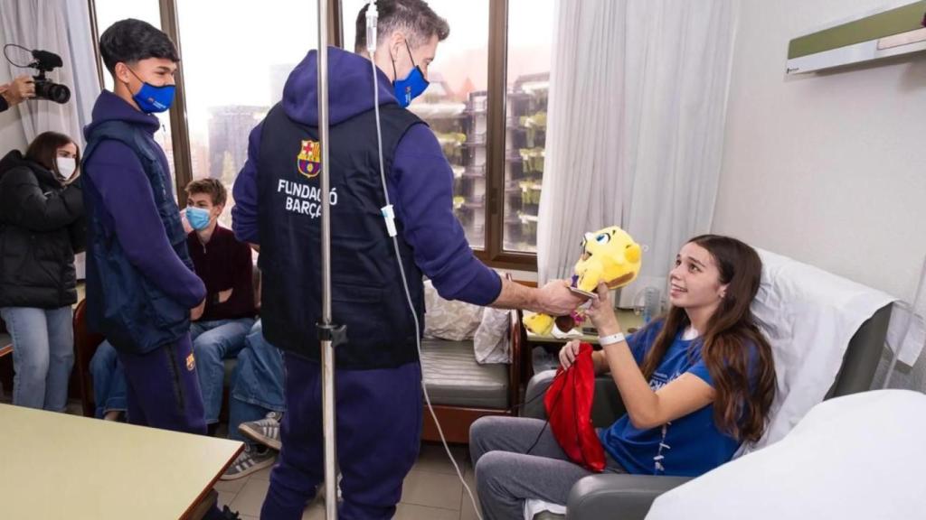 Dro Fernández y Robert Lewandowski regalan un peluche de CAT a una niña ingresada en el hospital