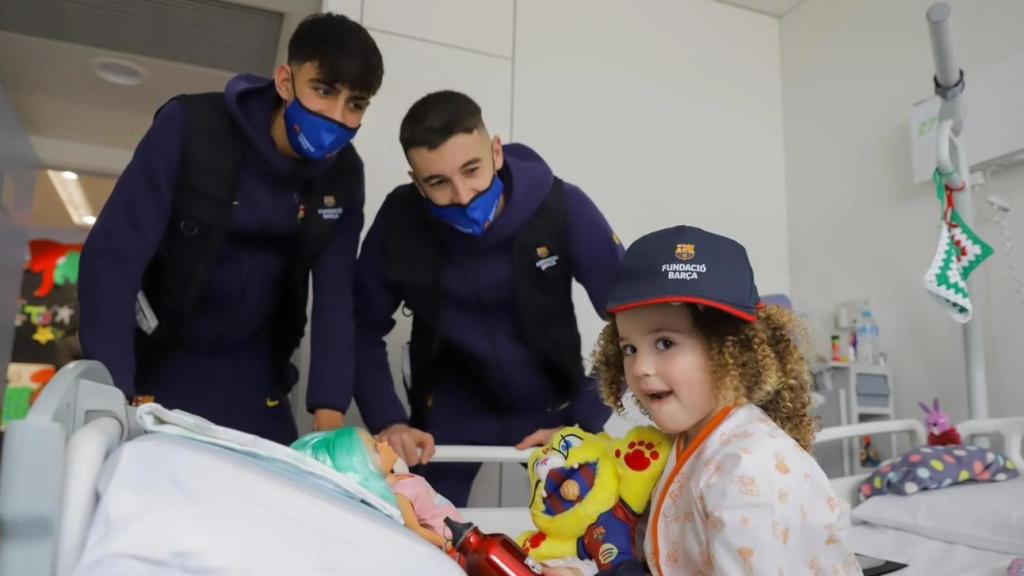 Marc Bernal i Joan García regalen un peluix de CAT a una nena hospitalitzada