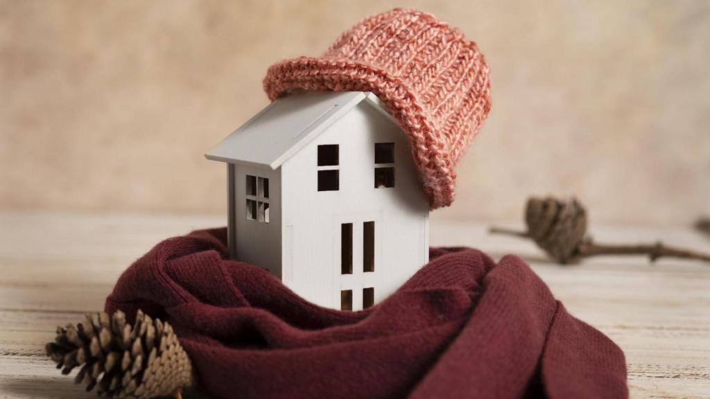 Casita de madera abrigada con bufanda y gorro