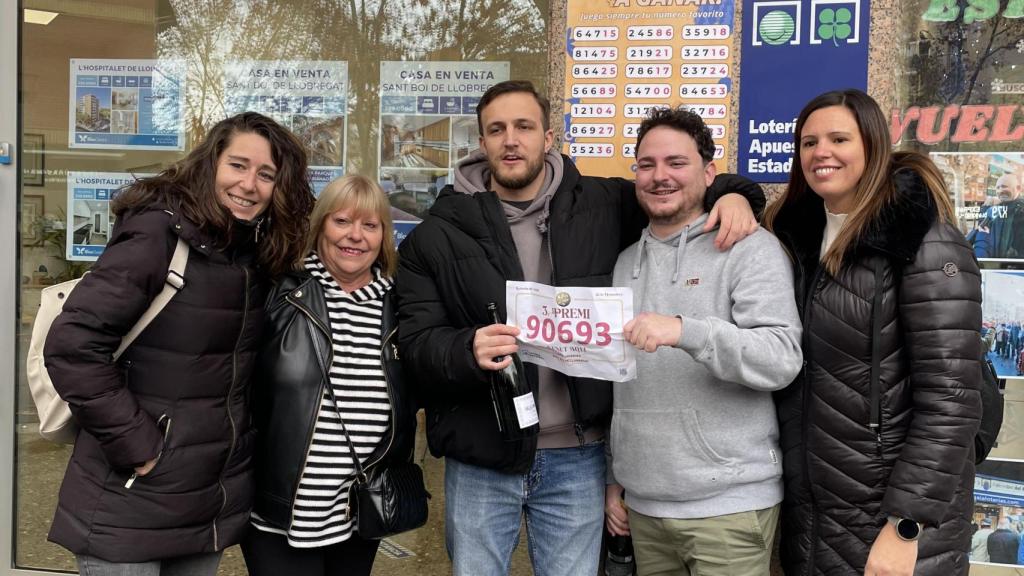Dos amigos ganadores del tercer premio delante de la lotería