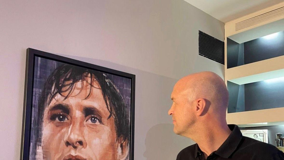 Jordi Cruyff observa un cuadro de Johan Cruyff con una copa en la mano