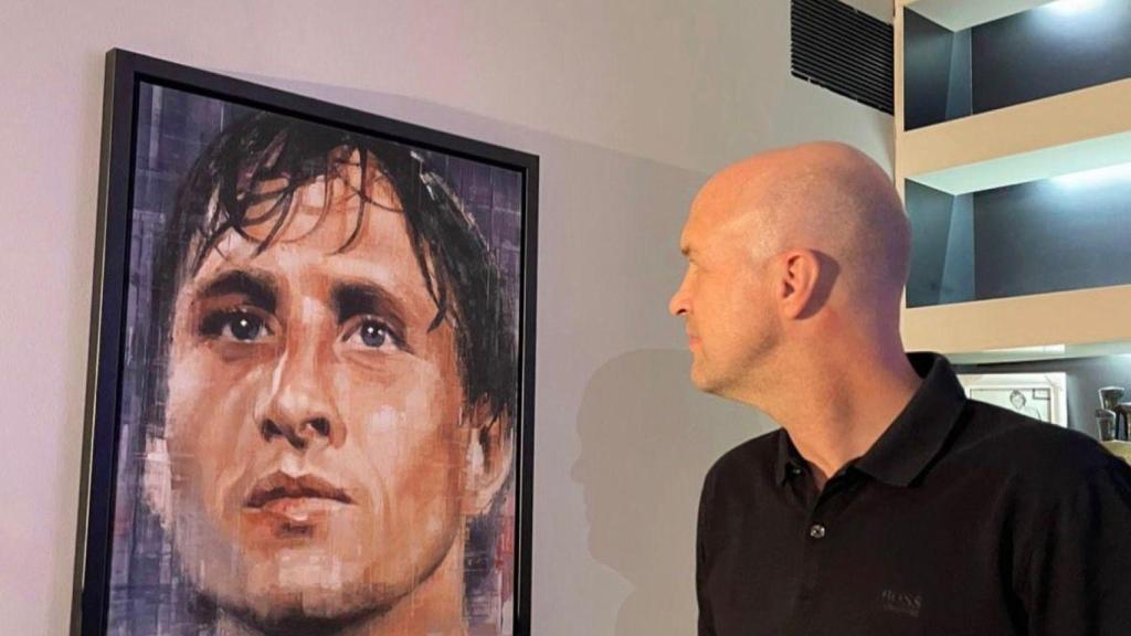 Jordi Cruyff observa un quadre de Johan Cruyff amb una copa a la mà