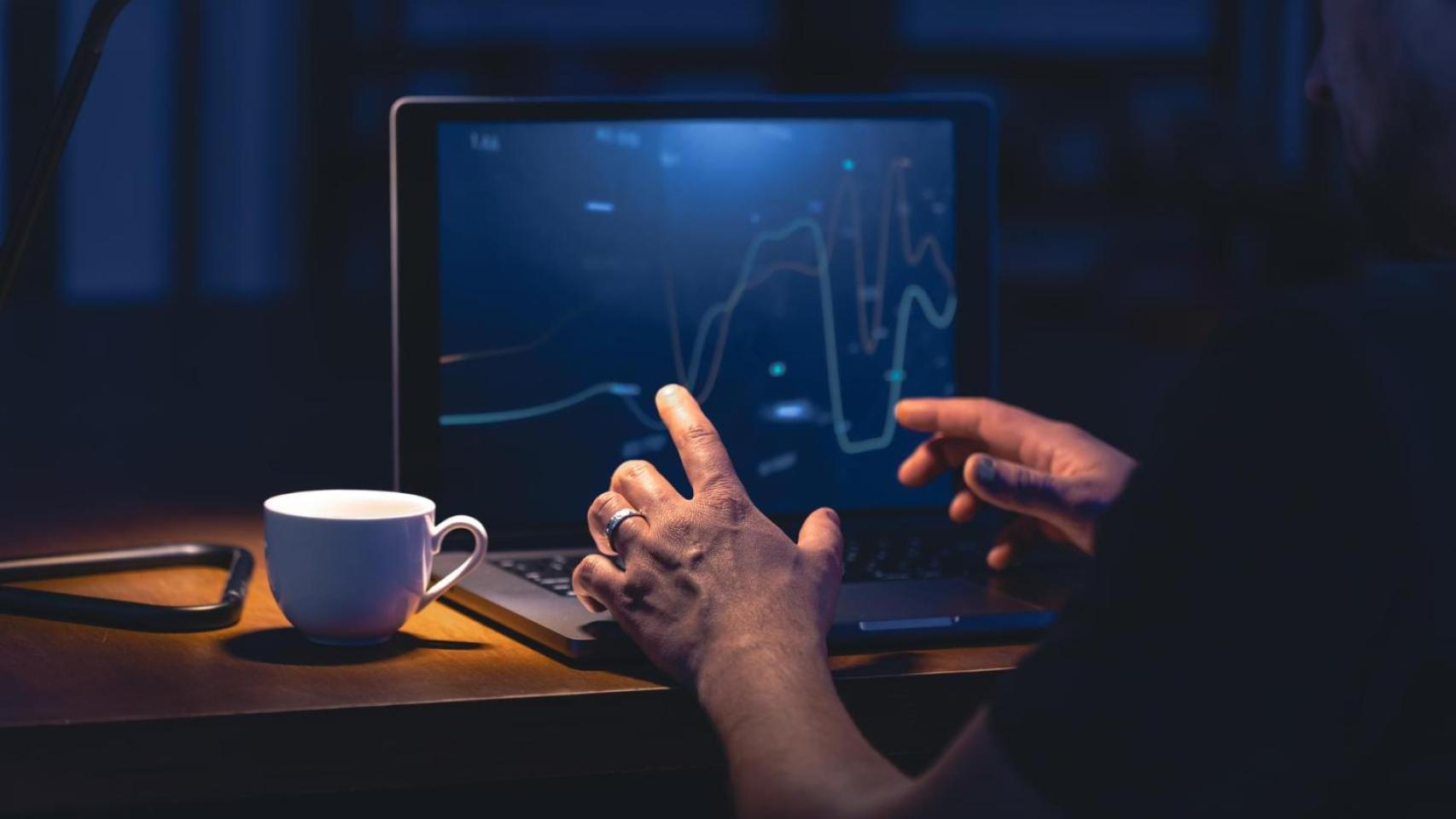 Hombre negocia inversiones desde un ordenador portátil