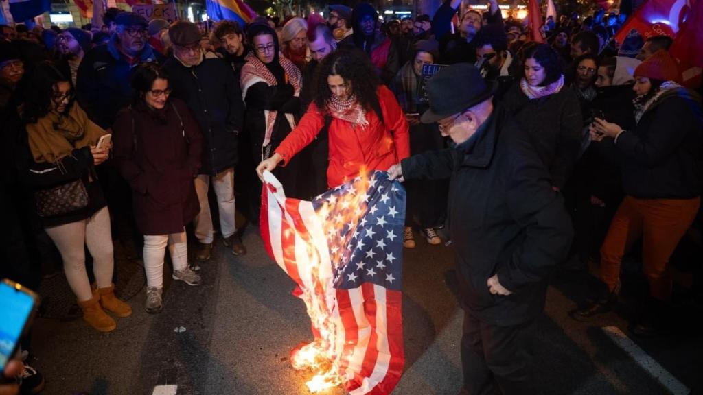 Quema de una bandera de EEUU en la concentración de la plaza Urquinaona de Barcelona contra el derrocamiento de Nicolás Maduro