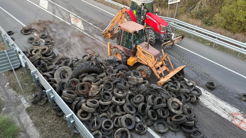 Un tractor retira neumáticos del corte de la AP-7