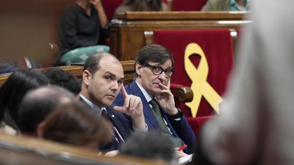 El presidente de la Generalitat, Salvador Illa, junto al 'conseller' de la Presidencia, Albert Dalmau, y un lazo amarillo en el escaño de Carles Puigdemont, en el Parlament
