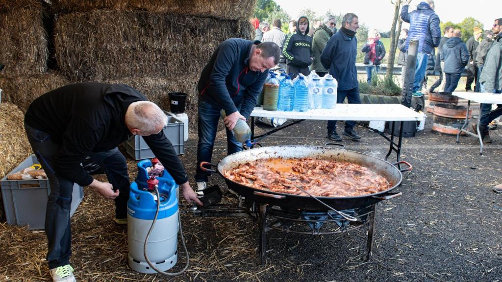 Agricultores y ganaderos preparan una paella este sábado mientras cortan la AP-7 con tractores y rollos de paja.