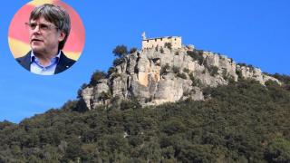 Vista contrapicada de Amer con una foto de Carles Puigdemont