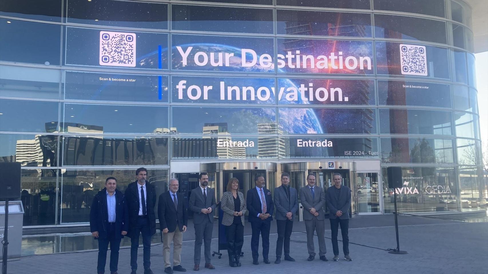 Autoridades y representantes empresariales posan ante la nueva pantalla en el recinto Gran Via de Fira de Barcelona