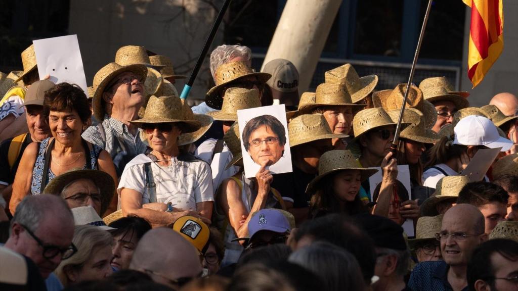 Seguidors independentistes amb barrets de palla i caretes amb la cara de Carles Puigdemont el dia de la seva reaparició i posterior desaparició a Barcelona