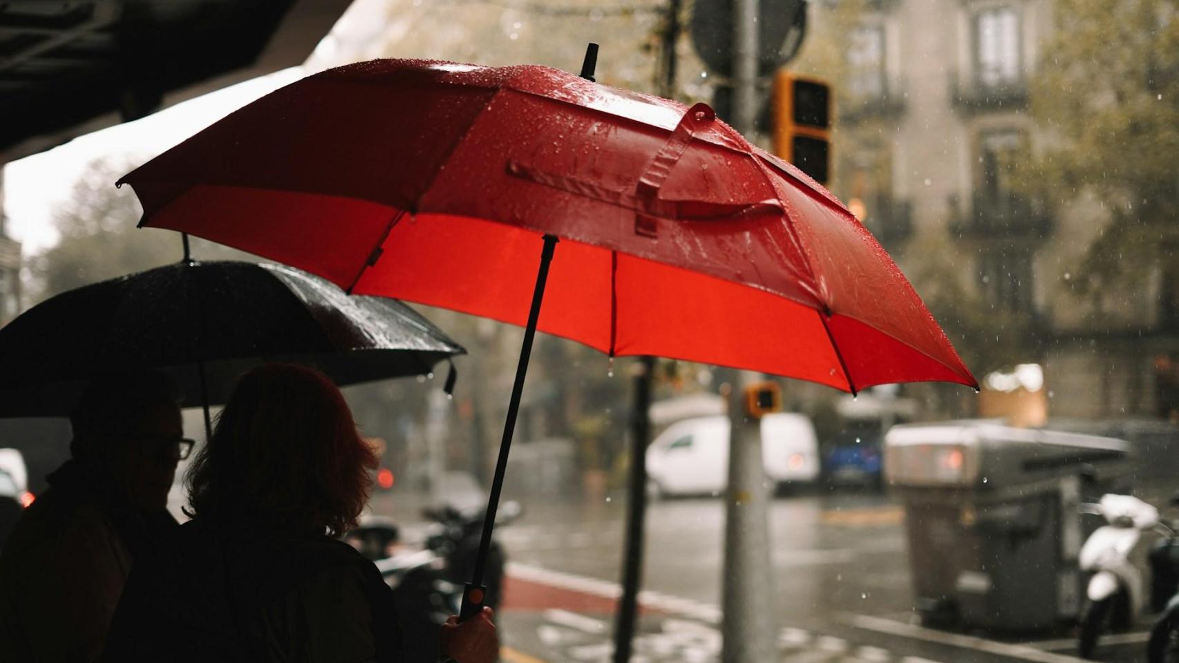 Una pareja se refugia de las fuertes lluvias en Barcelona